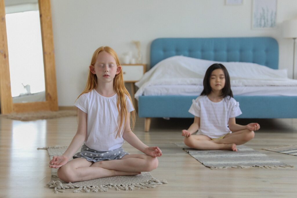 two children meditate in a bedroom