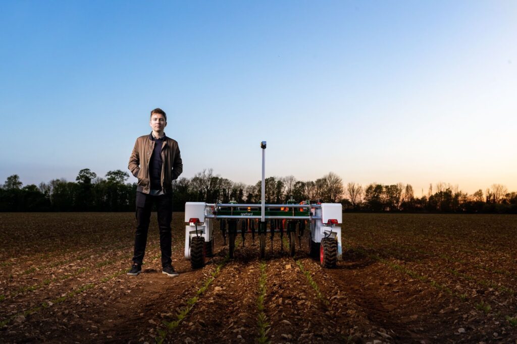 man standing near an agricultural robot