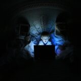 child reading a laptop at night