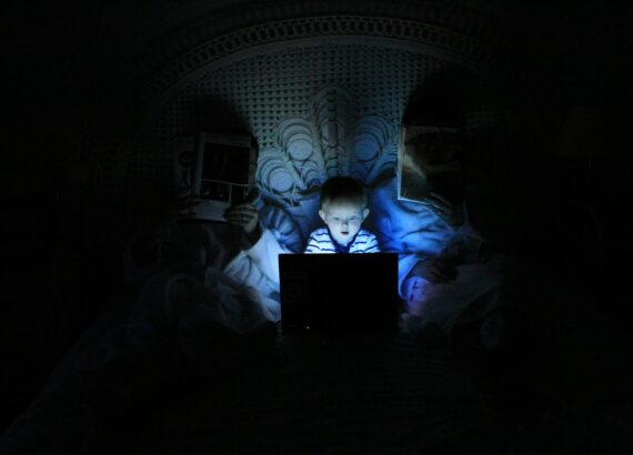 child reading a laptop at night