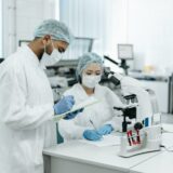 two scientists in a laboratory taking notes and doing research