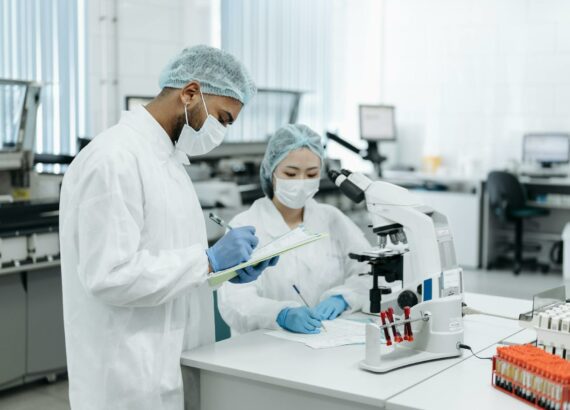 two scientists in a laboratory taking notes and doing research