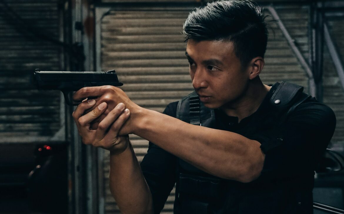 Man in a bulletproof vest aiming a pistol